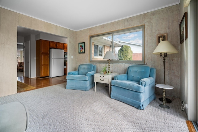 living area featuring carpet, ornamental molding, and wood finished floors