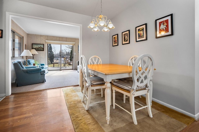 dining room featuring a notable chandelier, baseboards, and wood finished floors