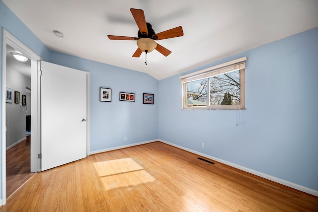 unfurnished bedroom with light wood finished floors, baseboards, visible vents, ceiling fan, and vaulted ceiling