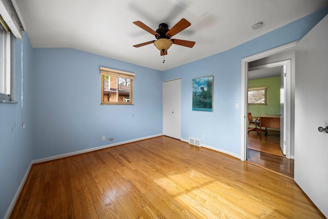 unfurnished bedroom featuring light wood-style flooring, a closet, visible vents, and baseboards