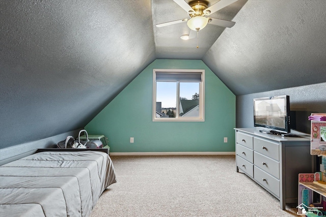 bedroom with a textured ceiling, lofted ceiling, and light colored carpet