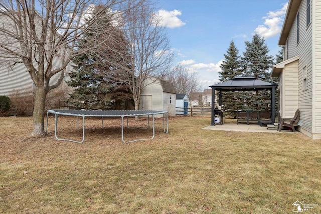 view of yard with a trampoline, a patio, a gazebo, and fence