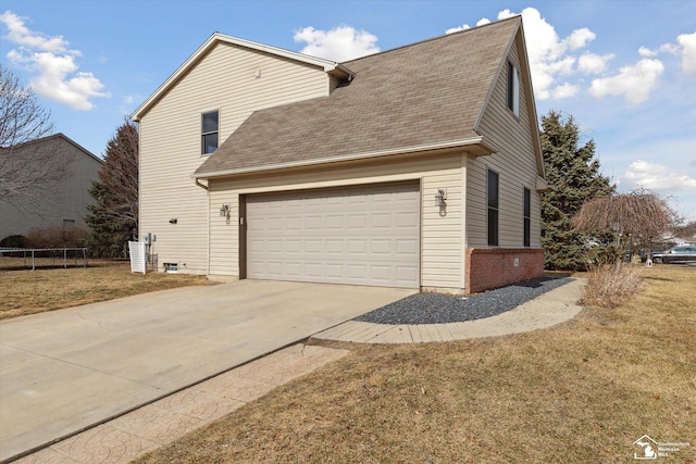 view of side of property with a garage, concrete driveway, a lawn, roof with shingles, and a trampoline