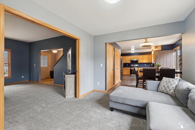 carpeted living room featuring baseboards