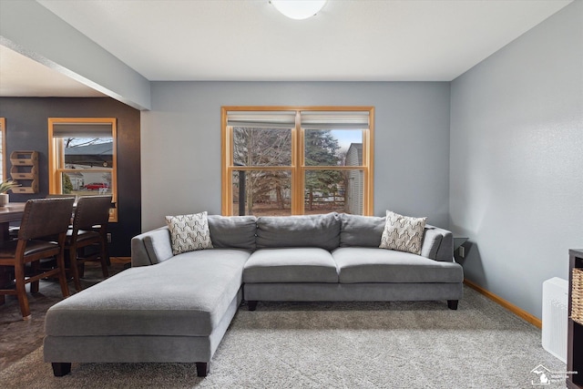 living room featuring carpet floors, plenty of natural light, and baseboards