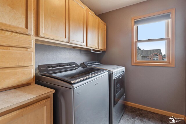 washroom featuring washer and dryer, cabinet space, and baseboards