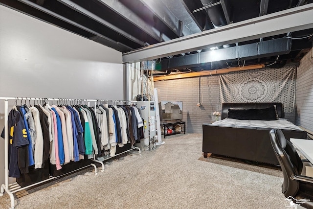 bedroom featuring brick wall and gas water heater