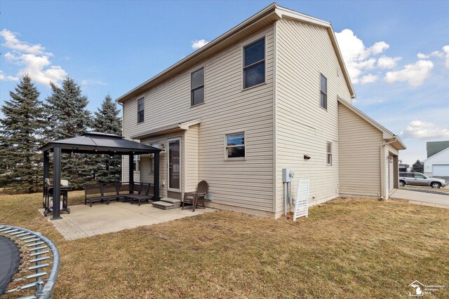 rear view of property featuring entry steps, a patio, an outdoor hangout area, a gazebo, and a yard