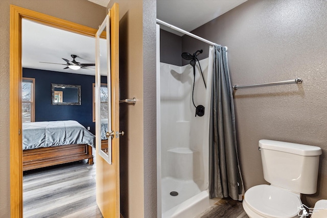 full bath with a textured wall, connected bathroom, toilet, wood finished floors, and a shower stall