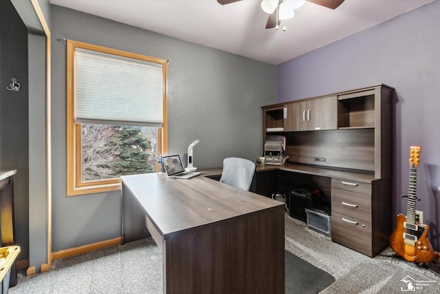 office featuring light carpet, baseboards, and a ceiling fan