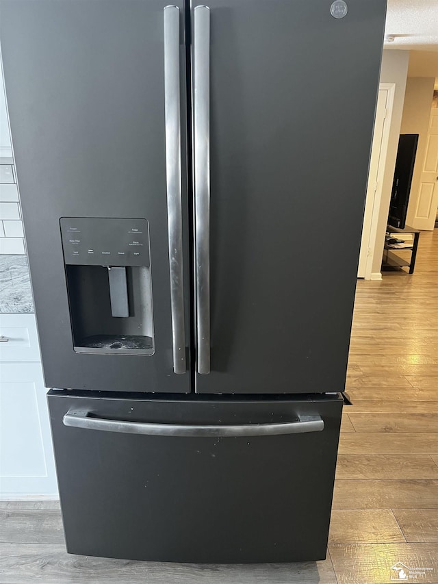 details featuring light wood-style flooring and stainless steel fridge with ice dispenser