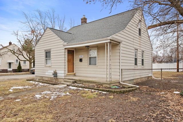 bungalow with roof with shingles, a chimney, and fence