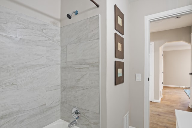 full bath featuring wood finished floors, tub / shower combination, baseboards, and visible vents