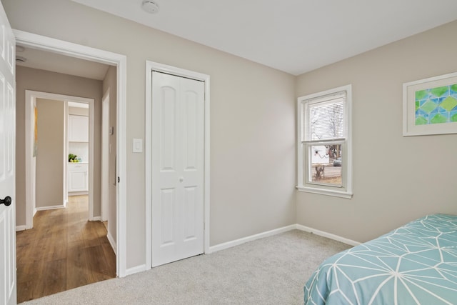 bedroom with a closet, baseboards, and carpet