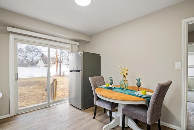 dining room featuring baseboards and light wood-style floors