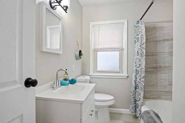 full bath featuring shower / bath combination with curtain, toilet, vanity, and baseboards