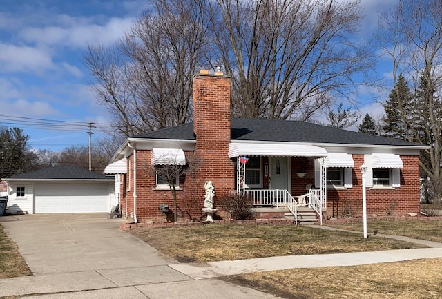 view of front of home featuring an outbuilding, brick siding, a detached garage, a front lawn, and a chimney