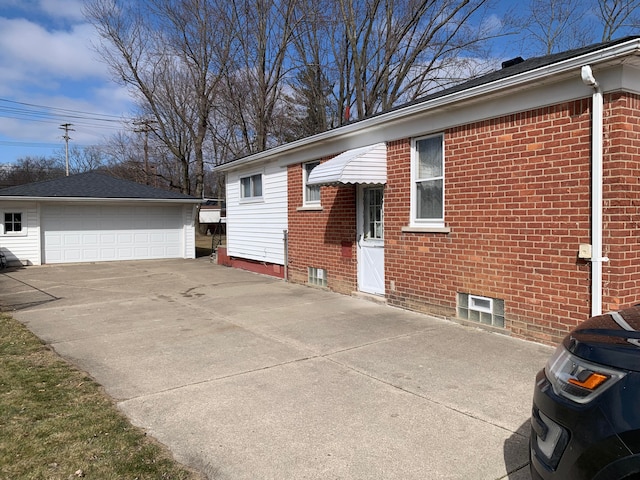 view of property exterior with a garage, brick siding, and an outbuilding