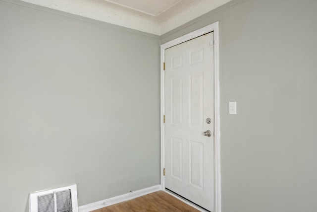 empty room with visible vents, baseboards, and wood finished floors