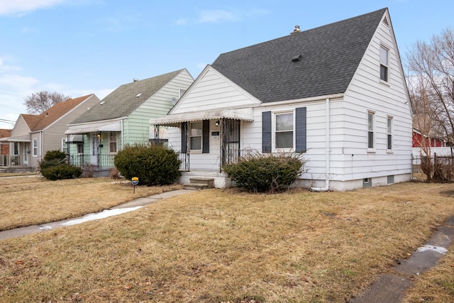 view of front of property with a front lawn and a shingled roof