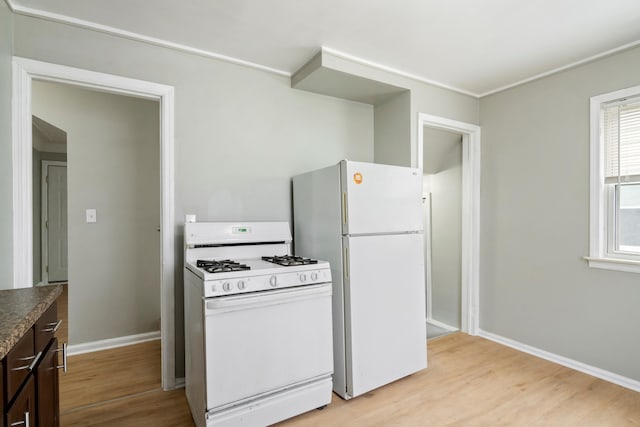 kitchen with light wood-style floors, white appliances, baseboards, and dark brown cabinets