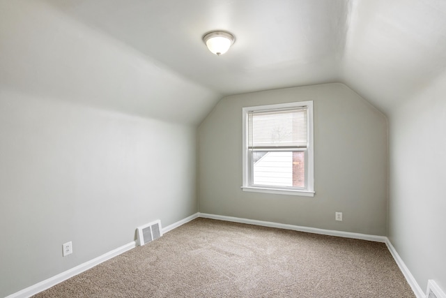 additional living space featuring vaulted ceiling, visible vents, and baseboards