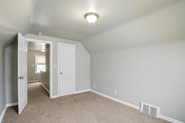 additional living space featuring carpet floors, visible vents, vaulted ceiling, and baseboards