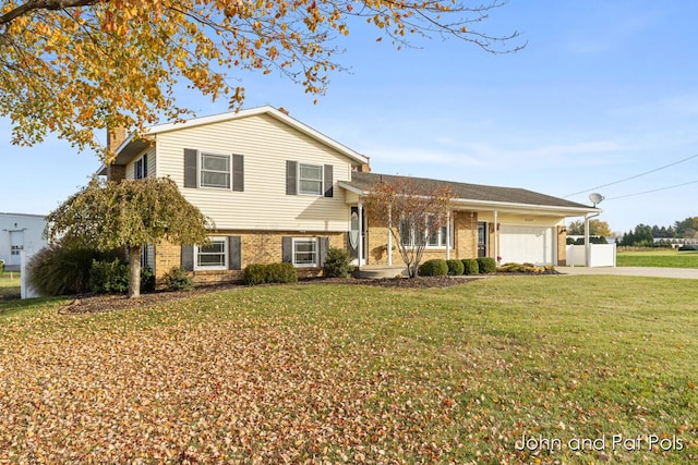 split level home featuring driveway, a garage, a chimney, a front lawn, and brick siding