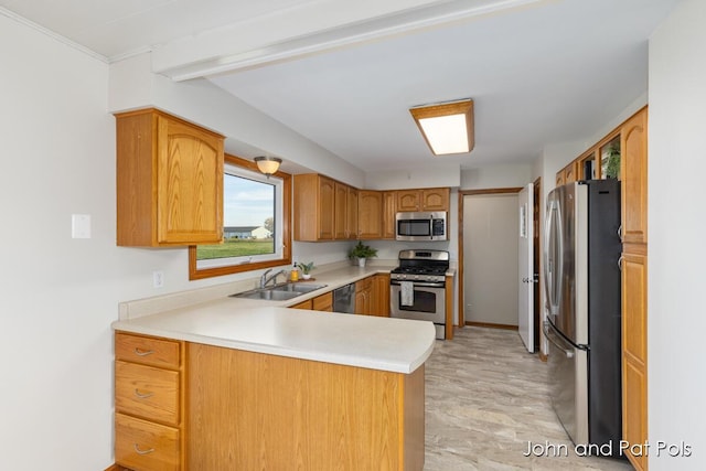 kitchen featuring stainless steel appliances, a peninsula, a sink, light countertops, and brown cabinetry