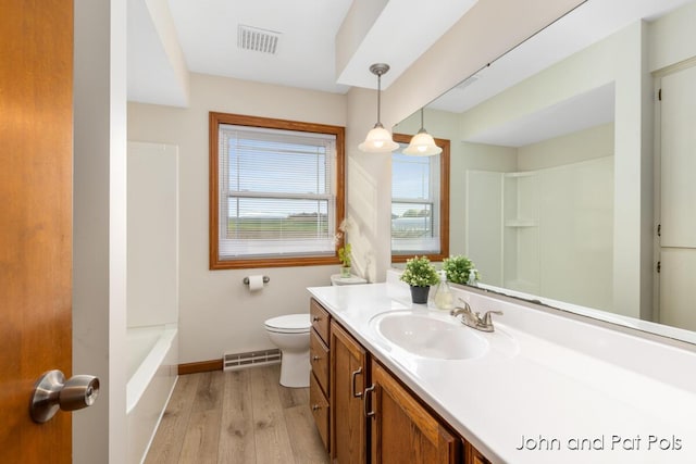 bathroom featuring toilet, visible vents, wood finished floors, and vanity