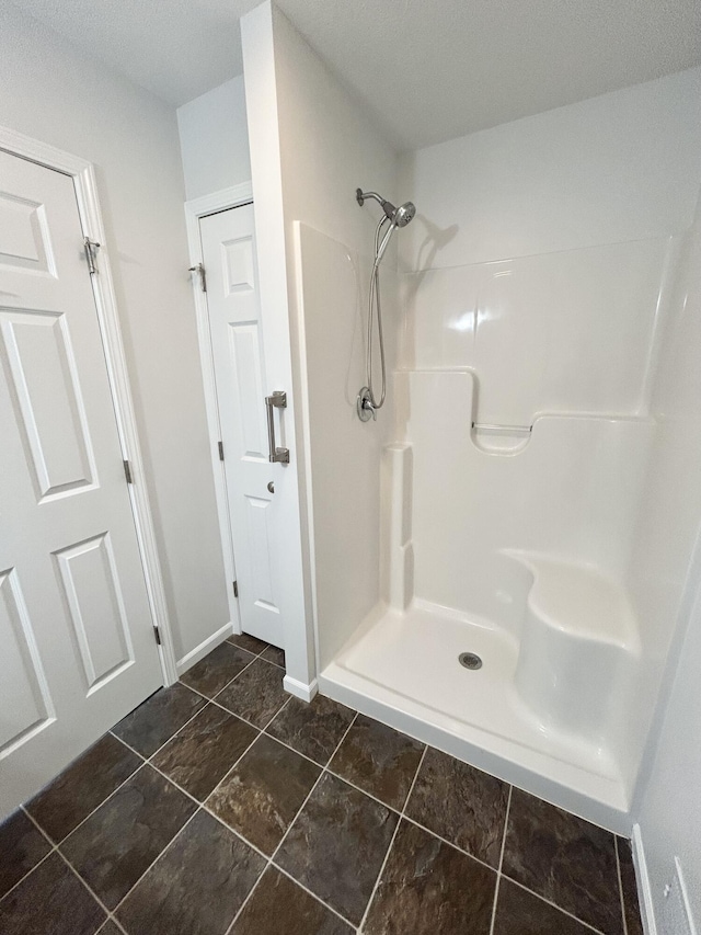 full bath with walk in shower and baseboards