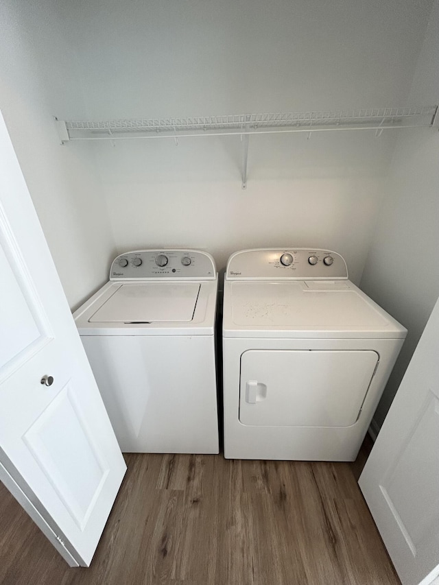 washroom featuring laundry area, washer and clothes dryer, and wood finished floors