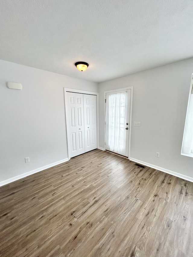 interior space featuring a textured ceiling, baseboards, and wood finished floors