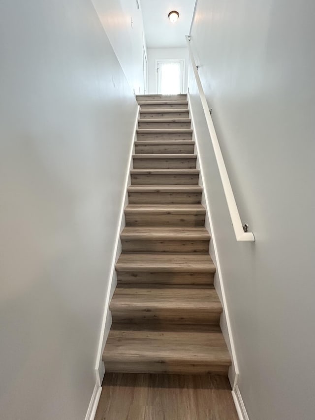 stairs featuring wood finished floors and baseboards