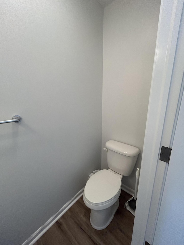 bathroom featuring toilet, baseboards, and wood finished floors