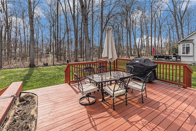 wooden terrace with outdoor dining space, a lawn, and area for grilling