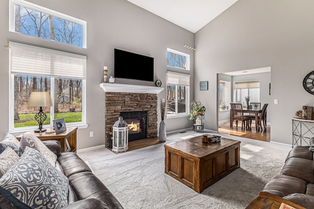 carpeted living room with high vaulted ceiling, a fireplace, and baseboards