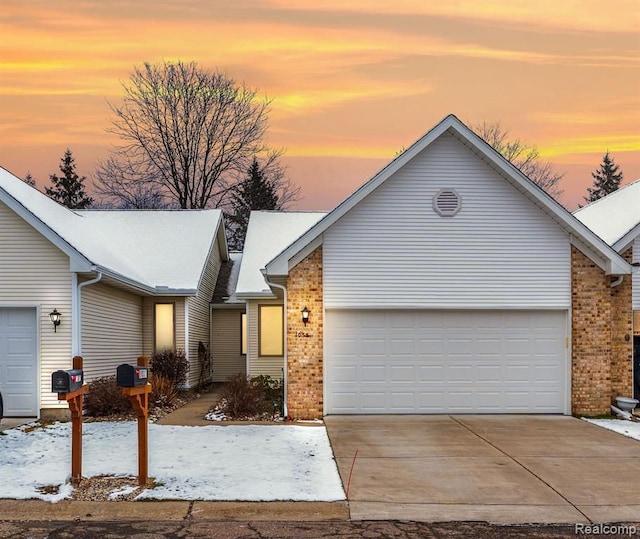 ranch-style house with a garage, concrete driveway, and brick siding