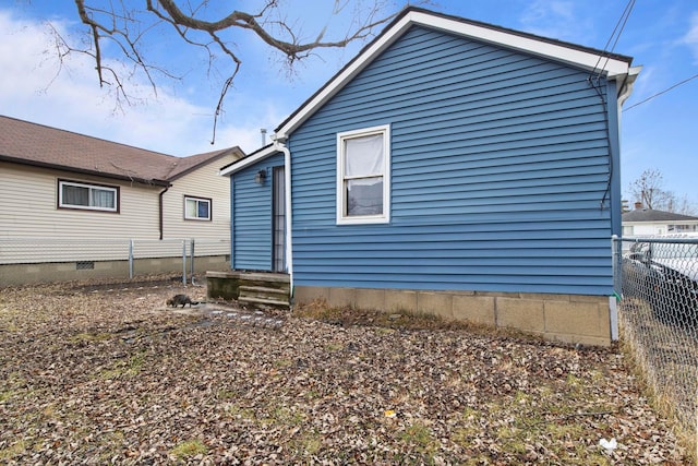 rear view of property with crawl space and fence