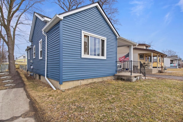 view of side of property featuring a yard and a porch