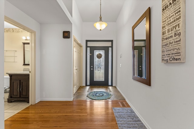 foyer entrance with light wood-style flooring and baseboards