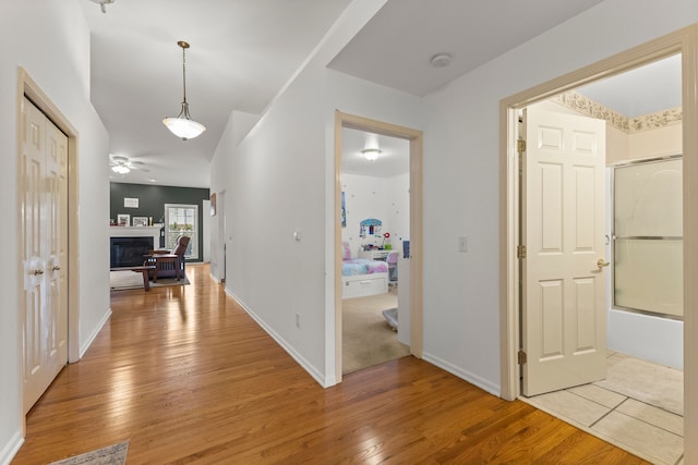 corridor with light wood-style flooring and baseboards