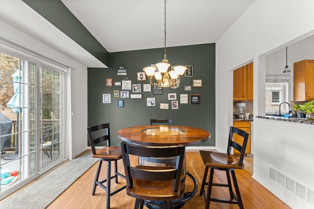 dining space featuring a healthy amount of sunlight, visible vents, baseboards, and light wood finished floors