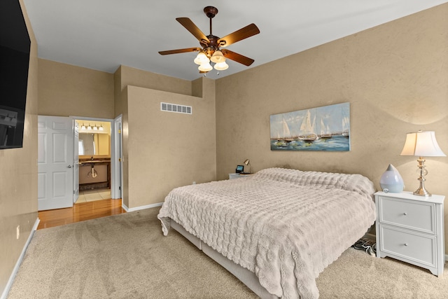 bedroom with carpet floors, visible vents, a ceiling fan, connected bathroom, and baseboards