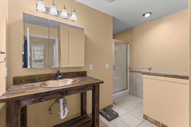 full bathroom featuring a sink, a shower stall, and tile patterned floors