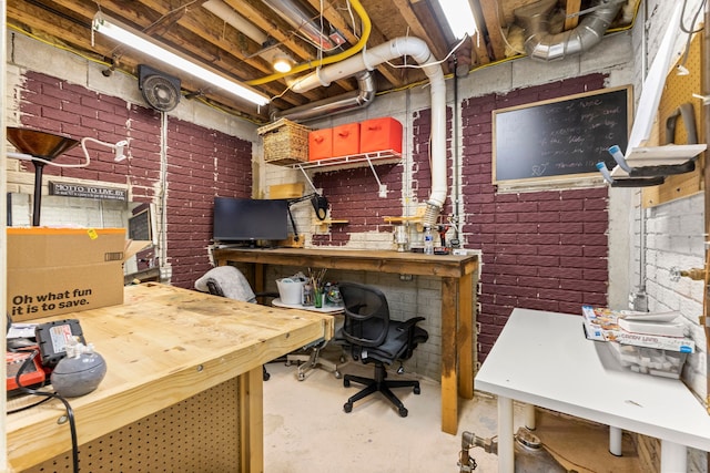 office space with concrete floors, brick wall, and a workshop area