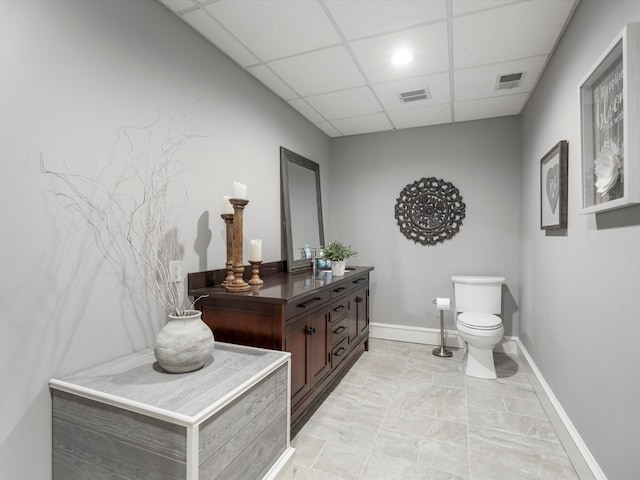 bathroom with toilet, a paneled ceiling, vanity, and visible vents