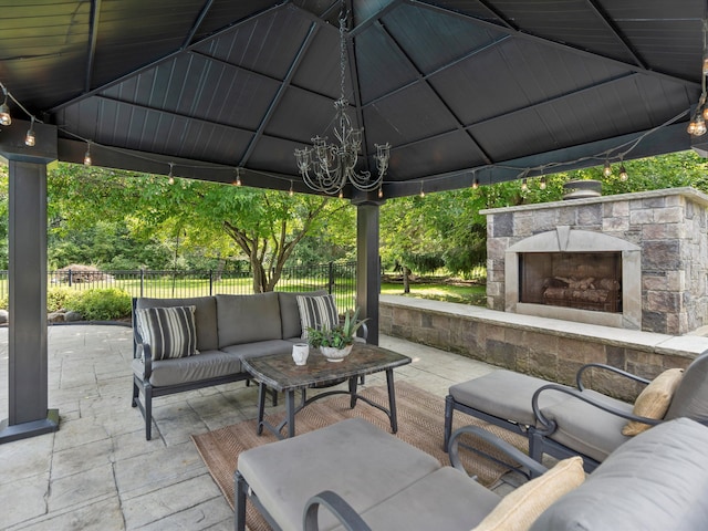 view of patio / terrace featuring a gazebo, an outdoor living space with a fireplace, and fence