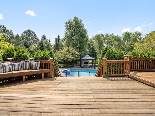 wooden deck featuring an outdoor pool and a gazebo