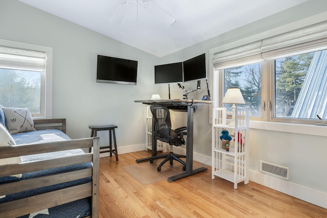 bedroom with baseboards, visible vents, vaulted ceiling, and wood finished floors